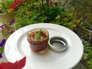 Oven-dried tomatoes in glass jar with olive oil and thyme